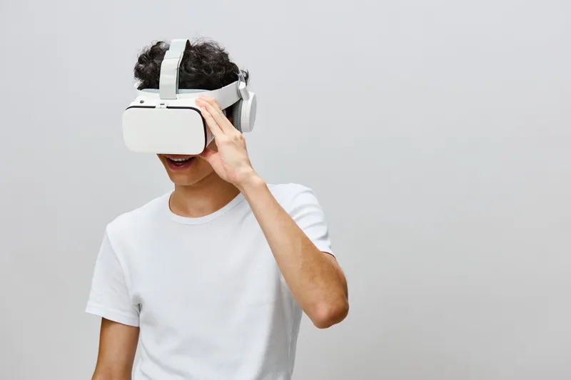 Молодой человек наслаждается опытом виртуальной реальности в VR-гарнитуре