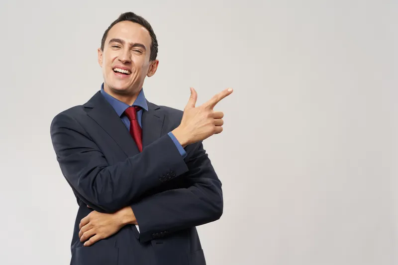 Улыбающийся бизнесмен жестом руки демонстрирует успех в официальной финансовой сфере