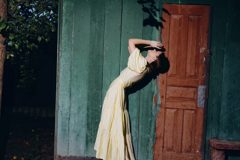woman dress wooden door sunlight vintage authenticity inclusivity