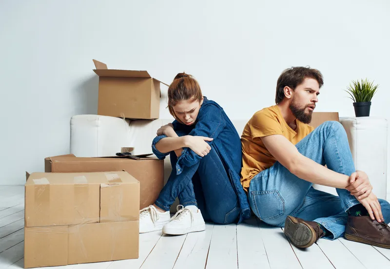 Молодая пара переезжает с коробками вещей