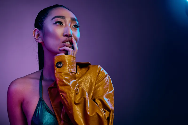 Красивая женщина с тёмными волосами, сияющая в студийном свете