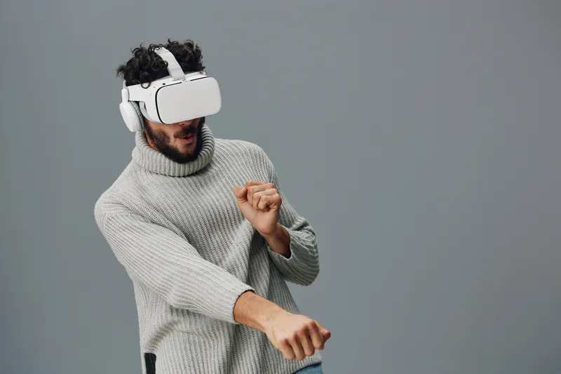 Мужчина использует современные VR-очки и гарнитуру, погружаясь в цифровую симуляцию или игру