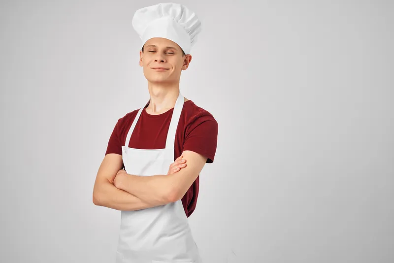 Мужчина в белом фартуке работает поваром на кухне, демонстрируя образ жизни