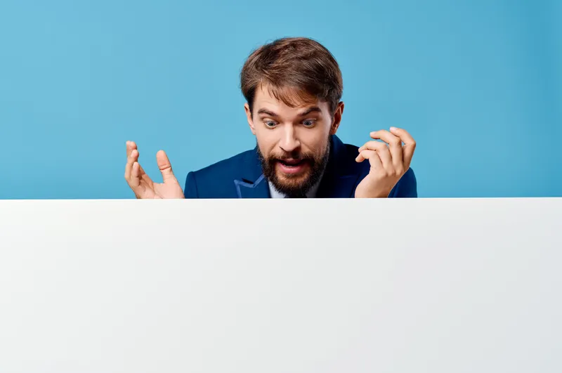 Бородатый мужчина рекламирует белый баннер на презентации на синем фоне