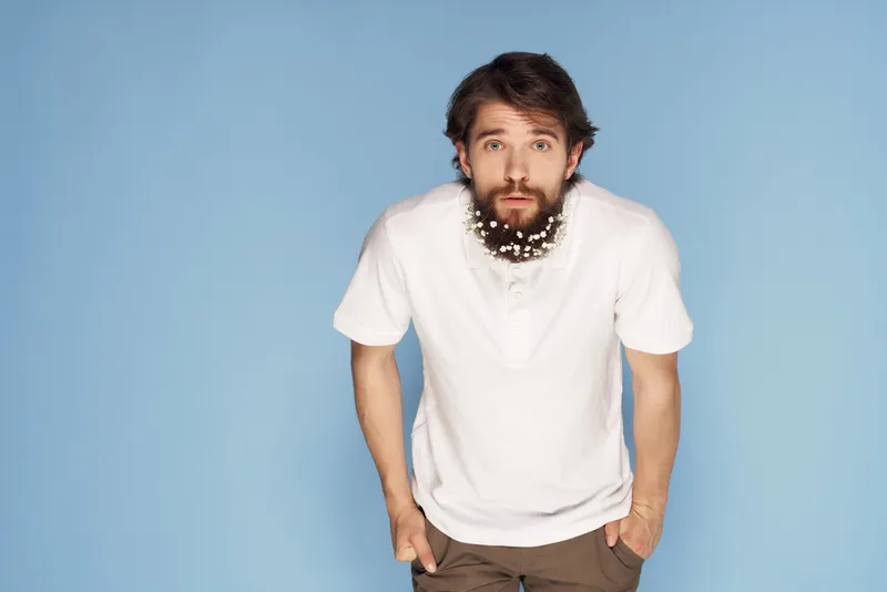Мужчина в белой рубашке с бородой, цветами, модный, позитивный, на голубом фоне
