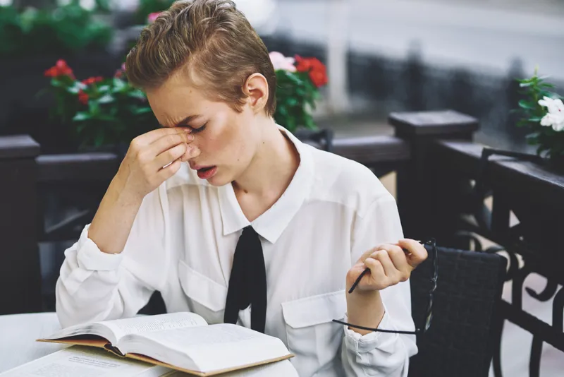 Женщина читает книгу за столиком в ресторане