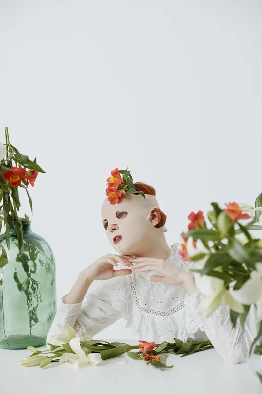 Unique artistic concept featuring a mannequin like figure adorned with flowers, conveying a surreal touch with a floral arrangement on a minimalist background