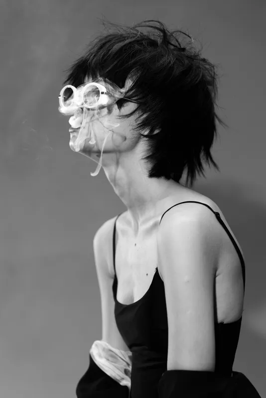 young woman wearing unusual glasses with shattered lenses, black and white portrait, artistic expression, edgy style