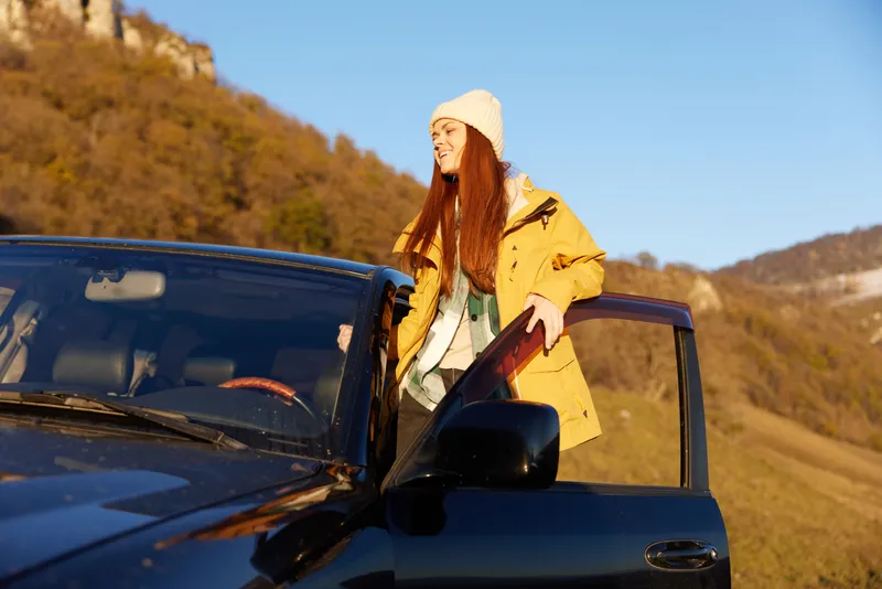 Женщина-путешественница у черного автомобиля