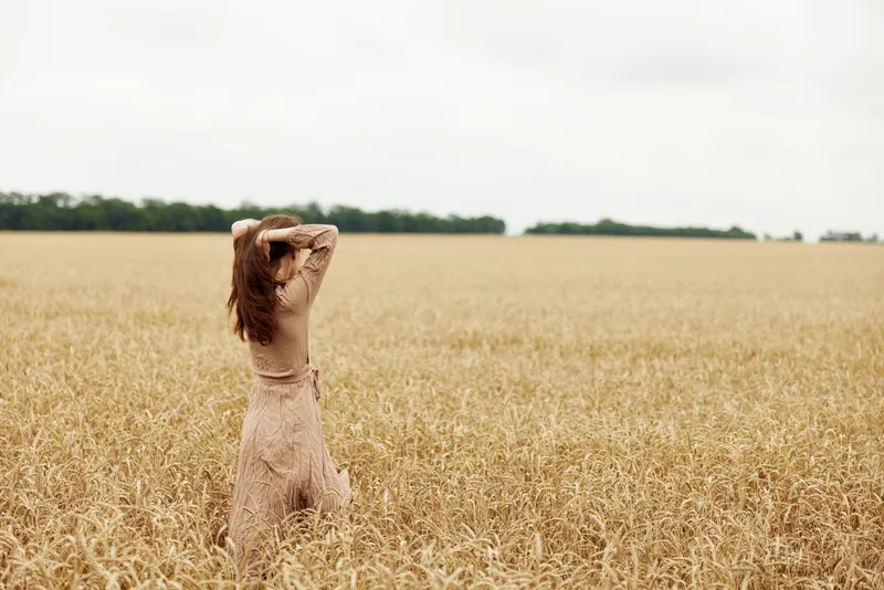 Женщина в сельской местности занимается промышленным выращиванием на бескрайнем поле