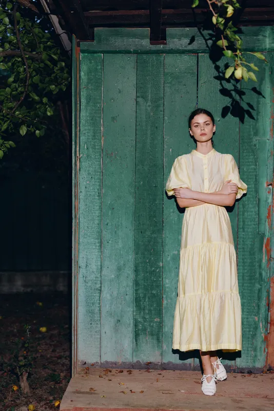 woman portrait in yellow vintage dress standing against green wall authenticity inclusivity