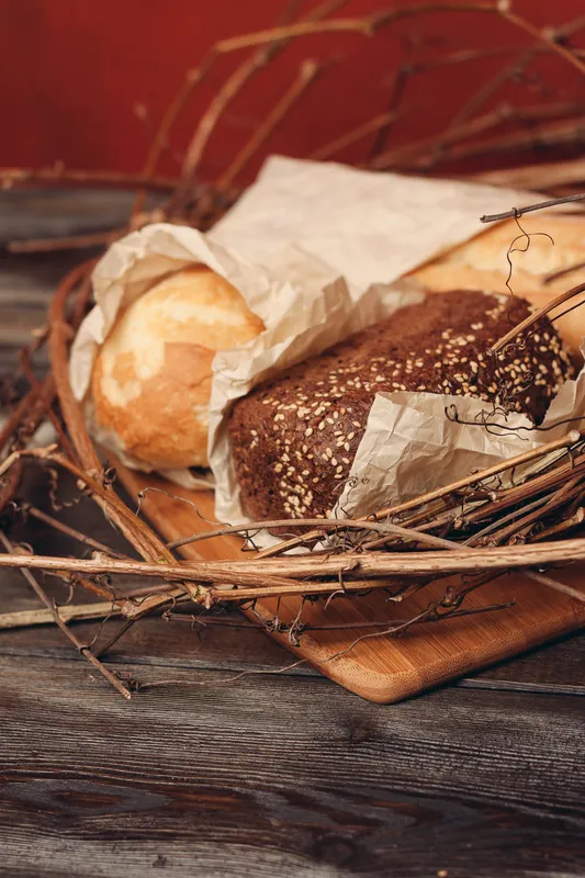 Выпечка буханки хлеба, мука, продукт в форме гнезда на деревянном столе