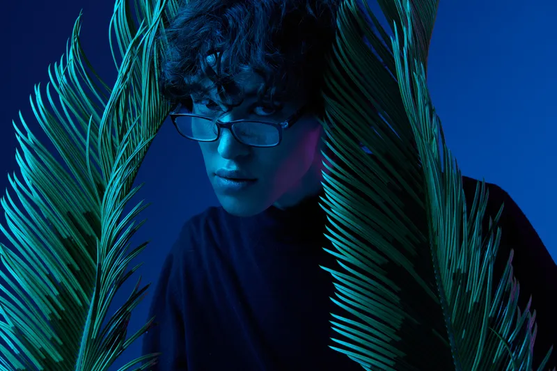 Мужчина в очках с пальмовыми листьями, портрет в стиле хипстерского образа жизни