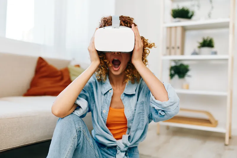 Виртуальная реальность: радостное indoor-развлечение женщины с футуристическими VR-очками и улыбкой