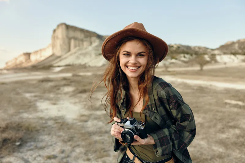 Счастливая женщина с фотоаппаратом запечатлевает красоту пустыни