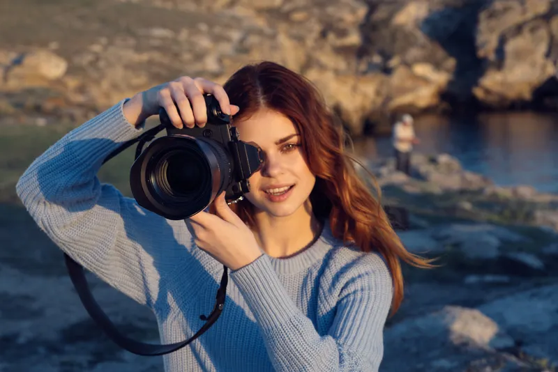 Жизнерадостная женщина-фотограф на природе в скалистых горах, хобби, профессионально