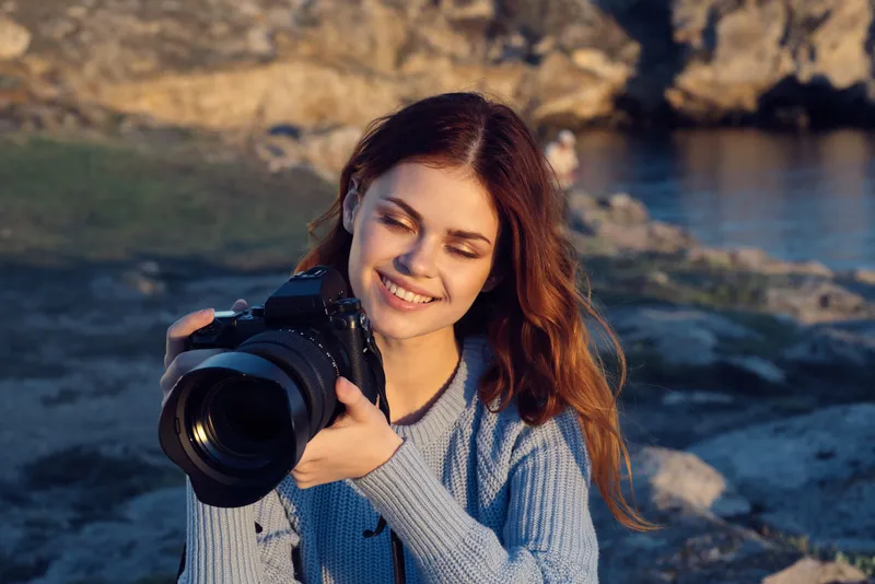 Симпатичная женщина-фотограф на природе в скалистых горах, приключение