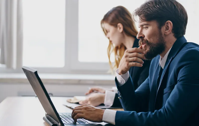 Коллеги по работе за офисным столом, технологии, финансовые профессионалы