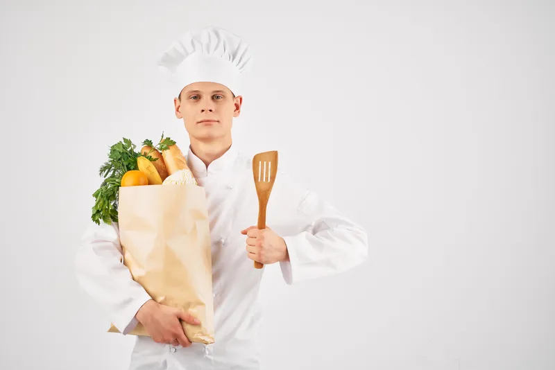 Мужчина в одежде шеф-повара с продуктовой упаковкой, здоровая еда, работа на кухне