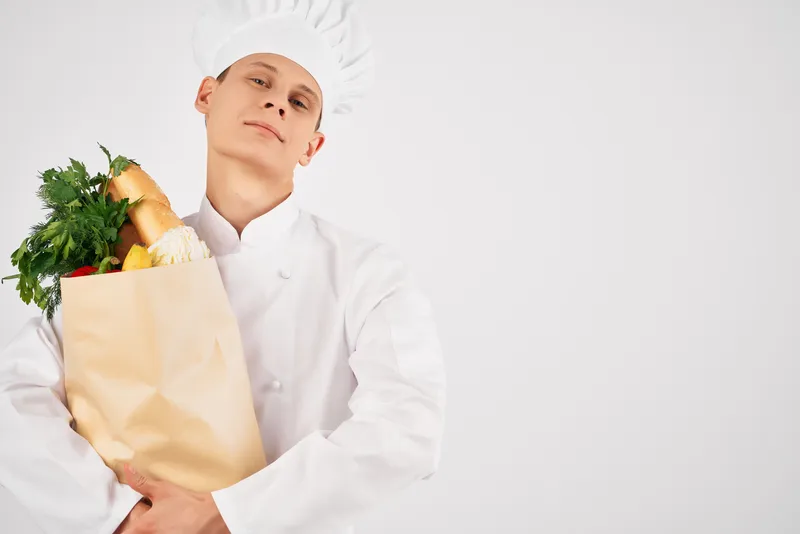 Мужчина в форме шеф-повара держит упаковку с продуктами, работа в ресторане