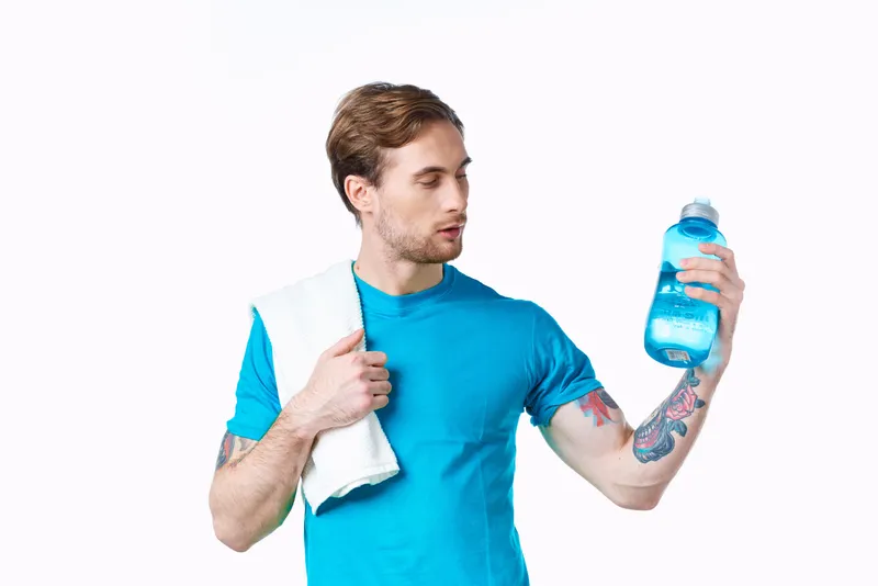 Спортсмен с полотенцем на плече и бутылкой воды, энергия, здоровье, тренировка