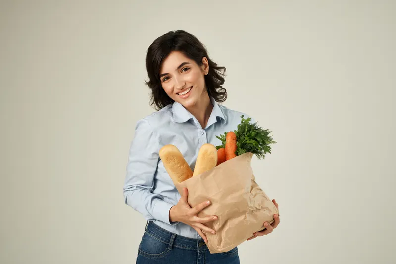 Женщина с пакетом продуктов в супермаркете