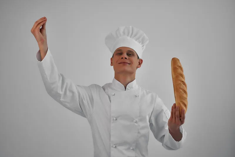 Весёлый мужчина с буханкой хлеба в руках, профессиональная закуска, свежая еда