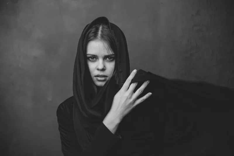 Портрет молодой женщины с тканью на голове, жестикулирующей руками