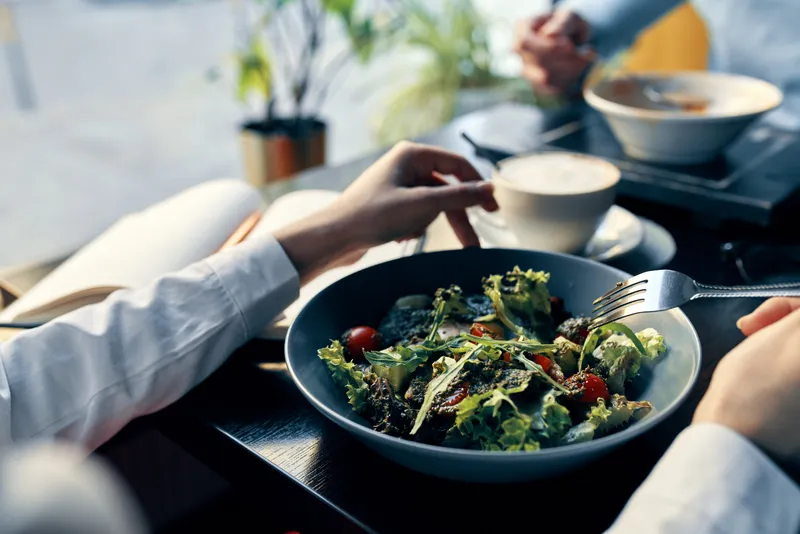 Свежий салат на тарелке, вкусная еда, диета, вилка в руке, женские руки, кафе