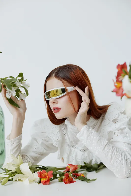 Young model in stylish sunglasses with flowers, expressing modern fashion trends and seasonal beauty, reflecting vibrant emotions and creative concepts
