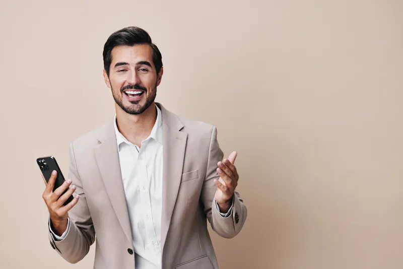 Мужчина разговаривает по смартфону, держа мобильное устройство в руке