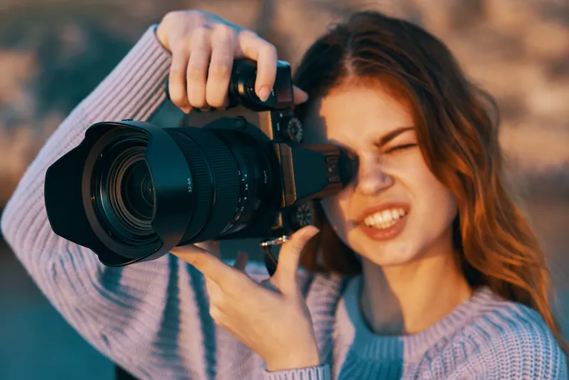 Красивая женщина-фотограф на природе в горах фотографирует модель на фоне пейзажа