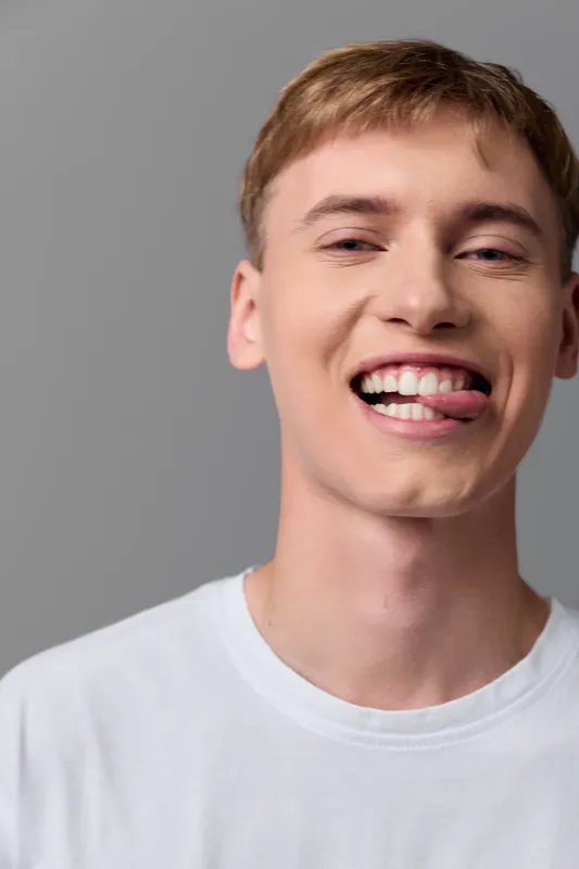 Smiling man in a casual white t-shirt with a bright expression and relaxed look, conveying happiness and approachable mood for lifestyle, marketing and everyday cheer.