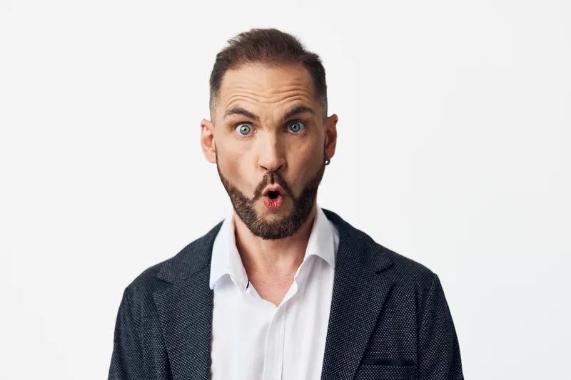 Professional man in business attire displays a surprised emotion against an isolated colored background, capturing a dynamic corporate moment ideal for marketing and presentation use.