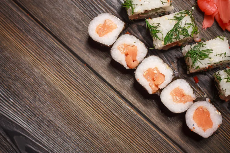 Имбирь, морепродукты, суши и роллы на деревянном столе
