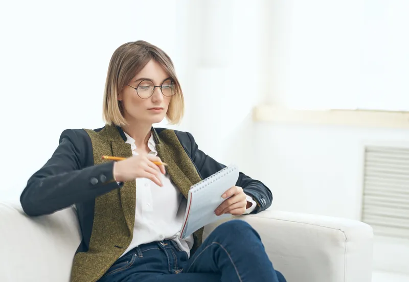 Женщина в очках работает с документами и резюме в офисе