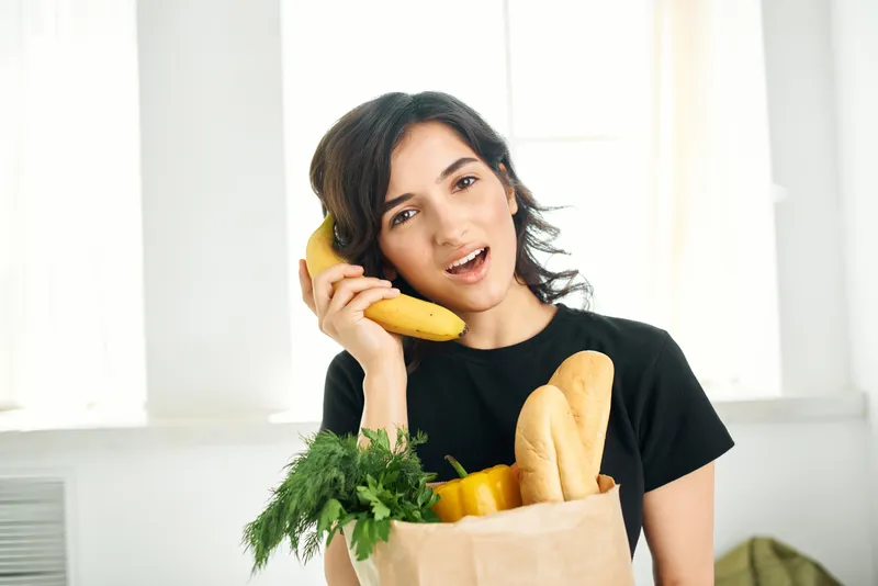 Брюнетка с пакетом продуктов дома, доставка здоровой еды