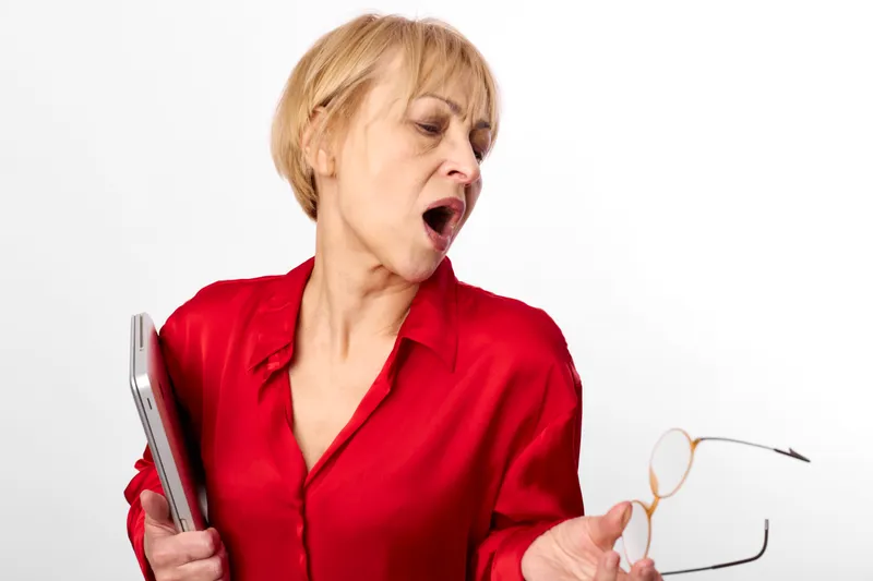 Woman with smartphone and glasses, surprise yawning expression, red blouse, studio portrait, white background, mature senior female indoors, copy space