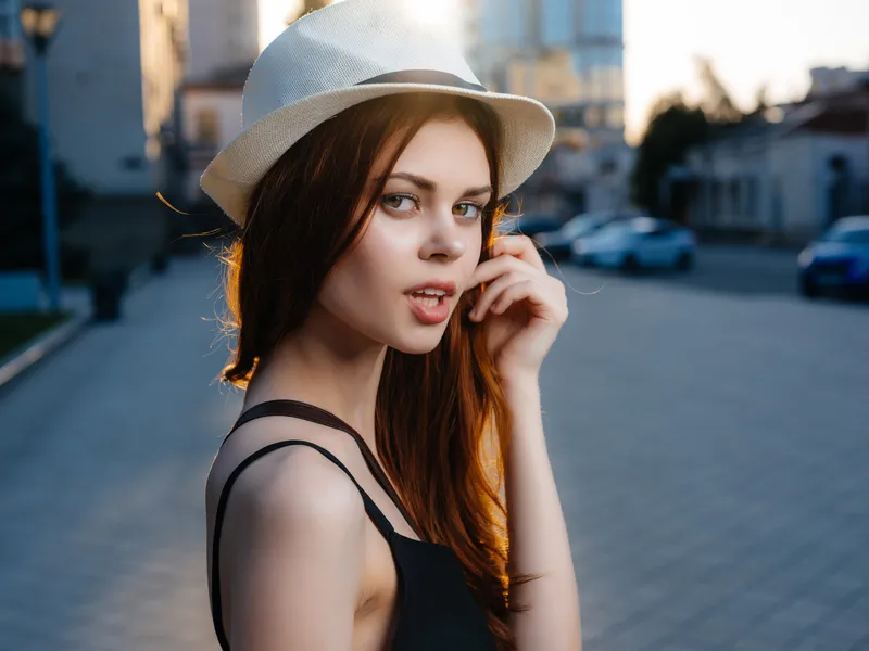 Симпатичная женщина в шляпе на улице, летние эмоции