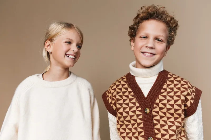 Authentic scene of two children at play, casual school inspired style, smiling and natural, capturing everyday life and genuine connection in a warm, candid moment.