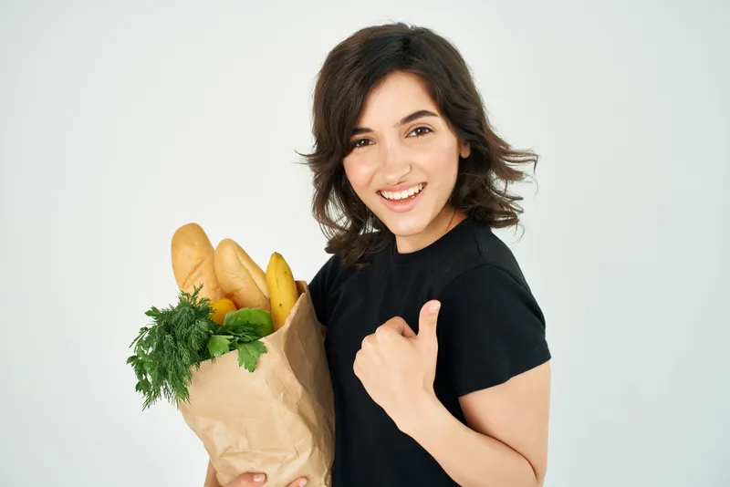 Весёлая брюнетка с пакетом продуктов