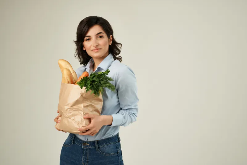 Женщина в осенних рубашках, я домохозяйка, с пакетом продуктов в супермаркете