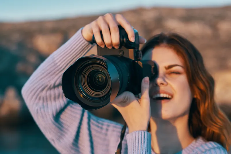 Счастливая женщина-фотограф на открытом воздухе в горах, профессиональная модель на фоне пейзажа