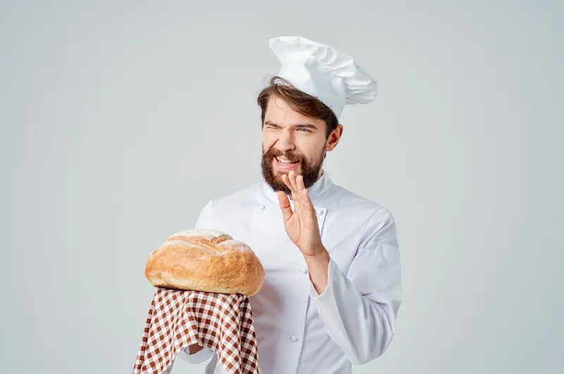 На фотографии запечатлён мужчина-повар на кухне, его профессиональные эмоции передают атмосферу работы