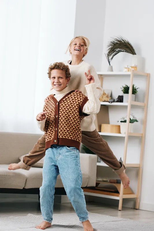 Authentic moment captures children at play, showcasing school themed lifestyle and active joy in a bright home setting, with smiles and motion.