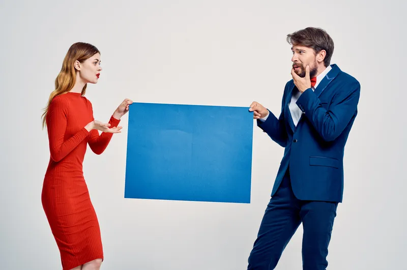 Милые мужчина и женщина позируют для постера в студии, рекламируя моду