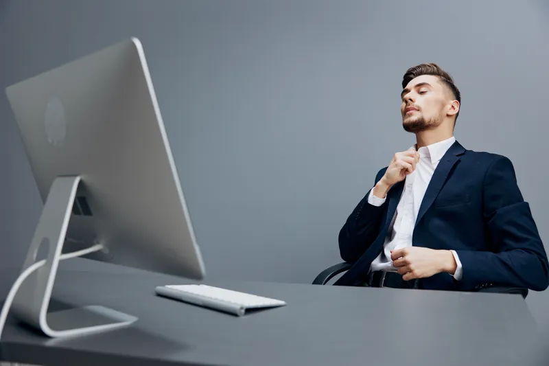 Бизнесмены с эмоциями работают перед компьютером в офисе