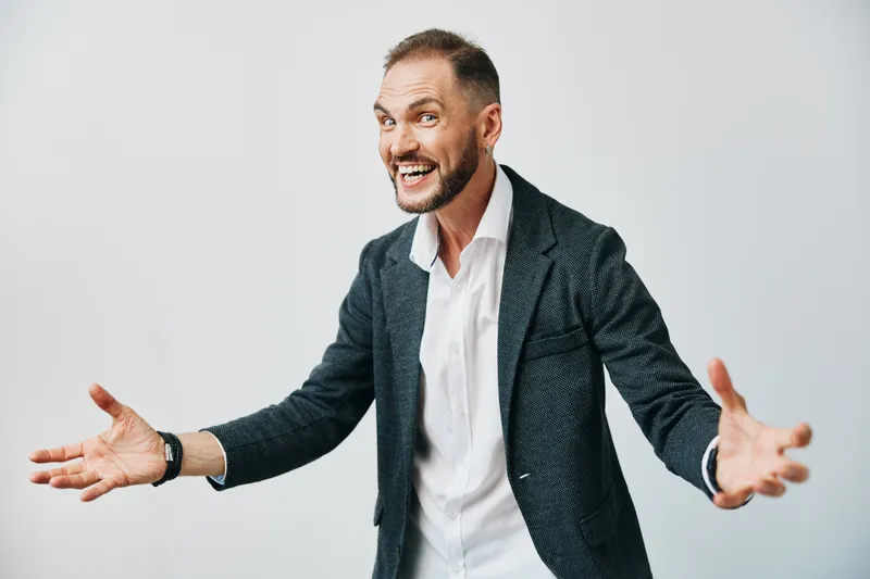 A confident business professional man with a warm smile stands against a bold, isolated colored backdrop, projecting openness, leadership, and clear communication in a dynamic, engaging pose.