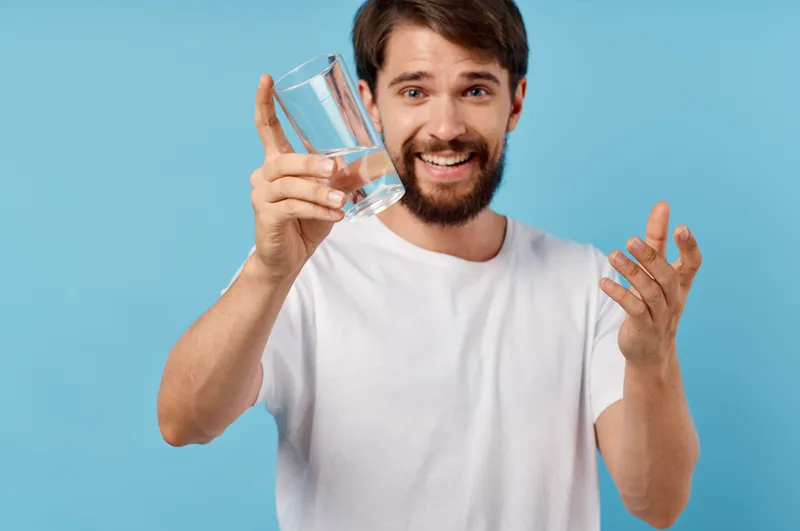 Бородатый мужчина со стаканом воды на изолированном фоне