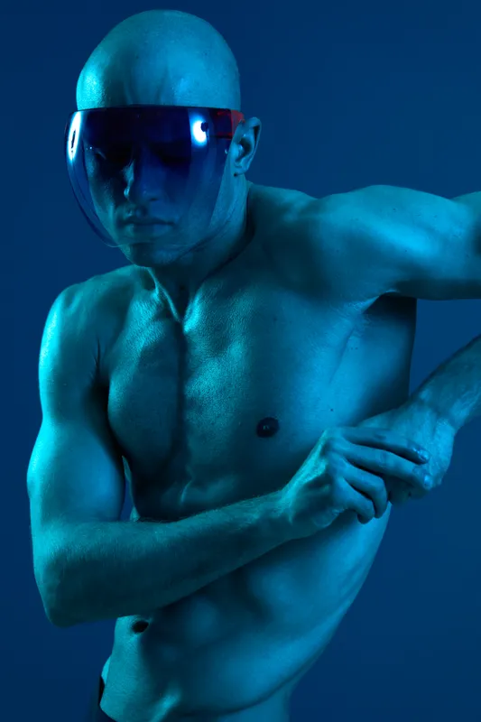 Athletic man posing in a striking blue tone, showcasing his physique, confidence, and dynamic movement. Captivating and bold imagery reflecting energy and strength.